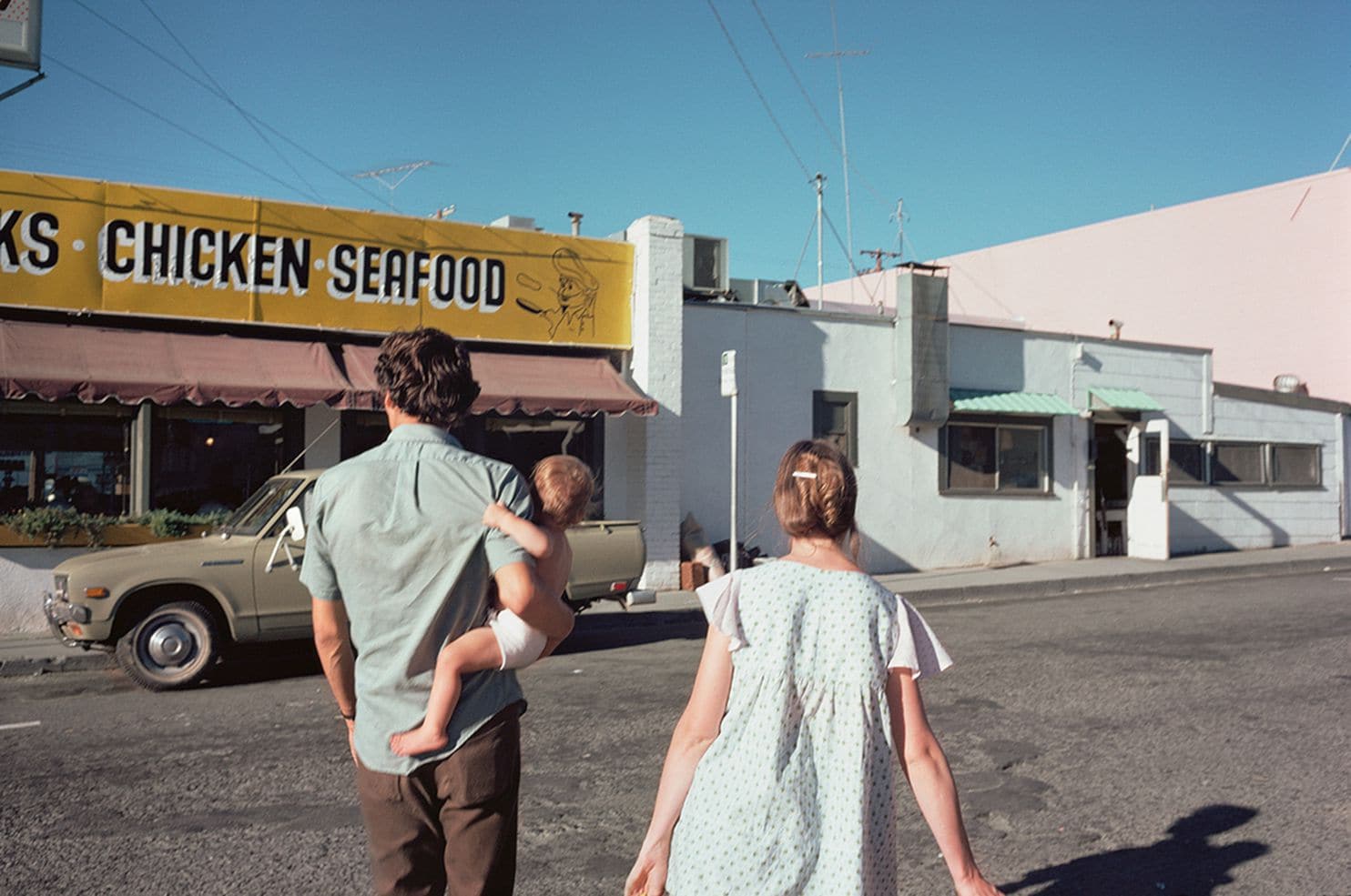 a man, woman, and child, walk to a store